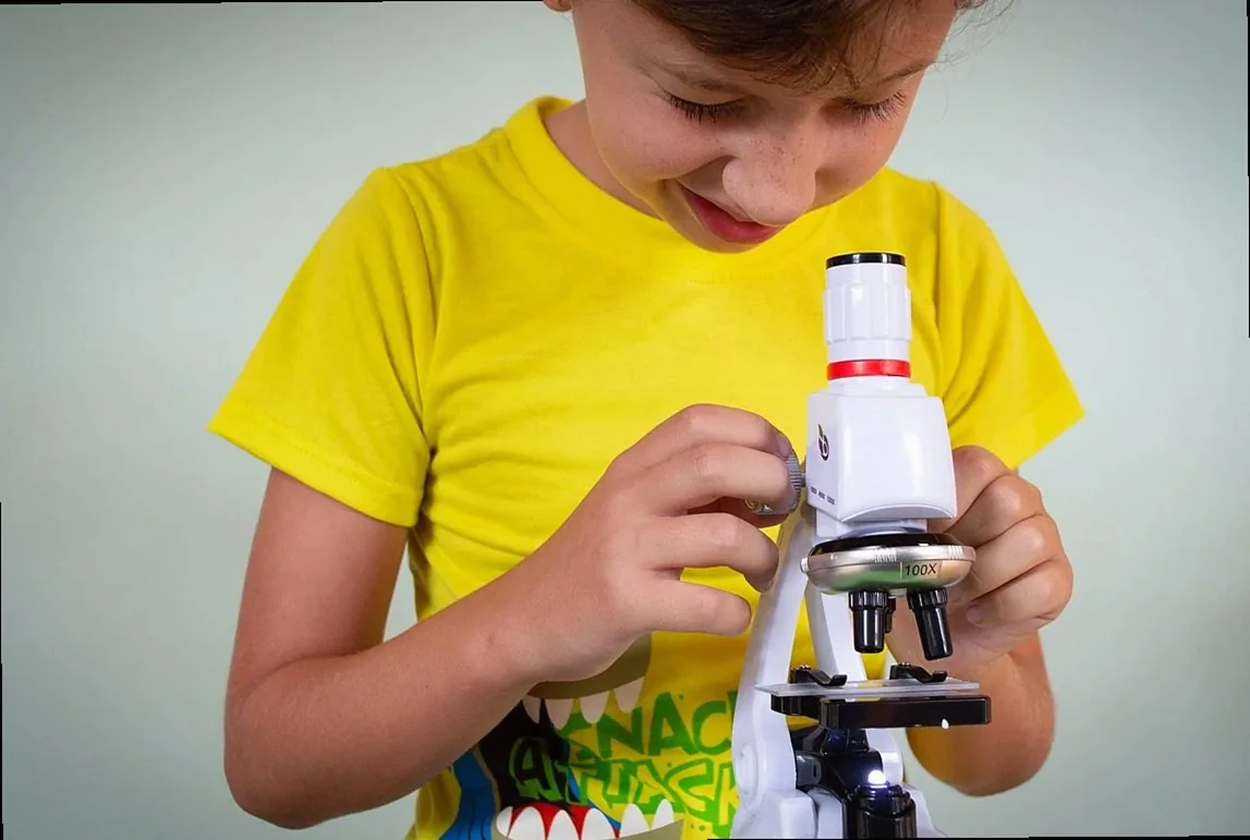 Child looking through a microscope