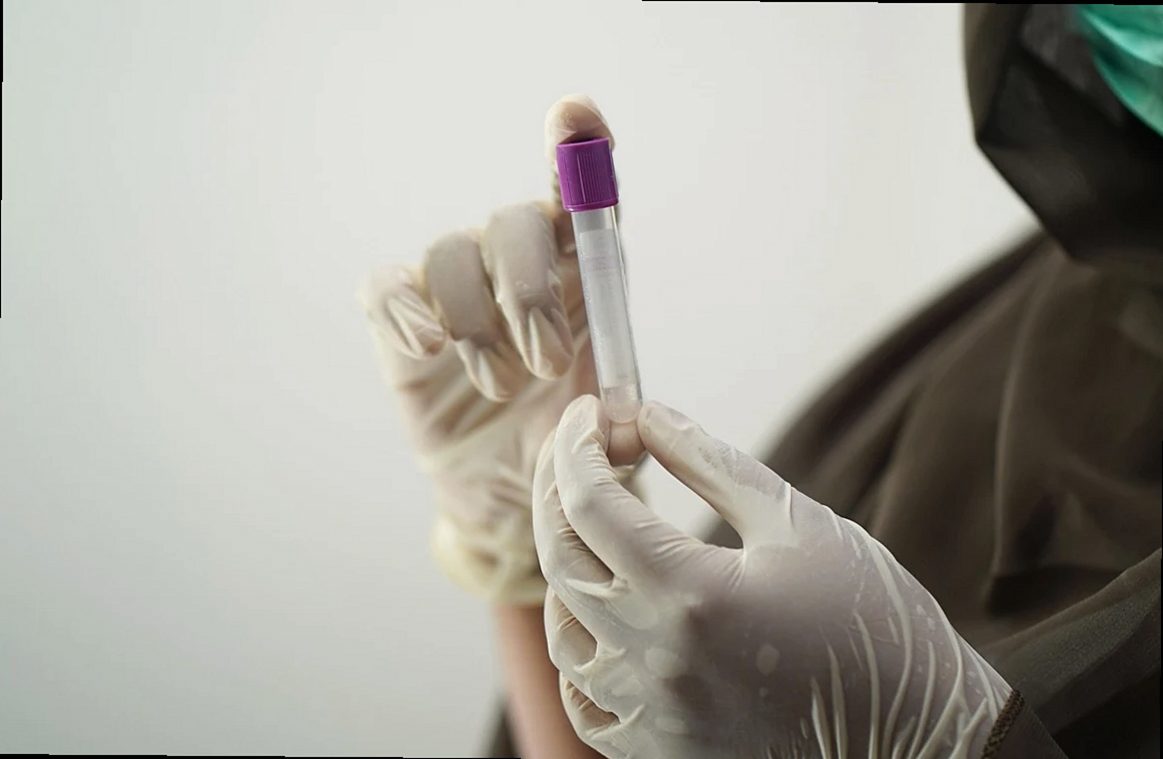 Gloved hands handling sample tubes